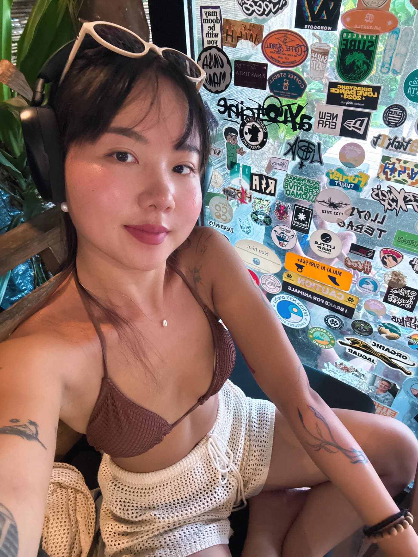 栗子戴着耳机的近照,双臂上是她的纹身
